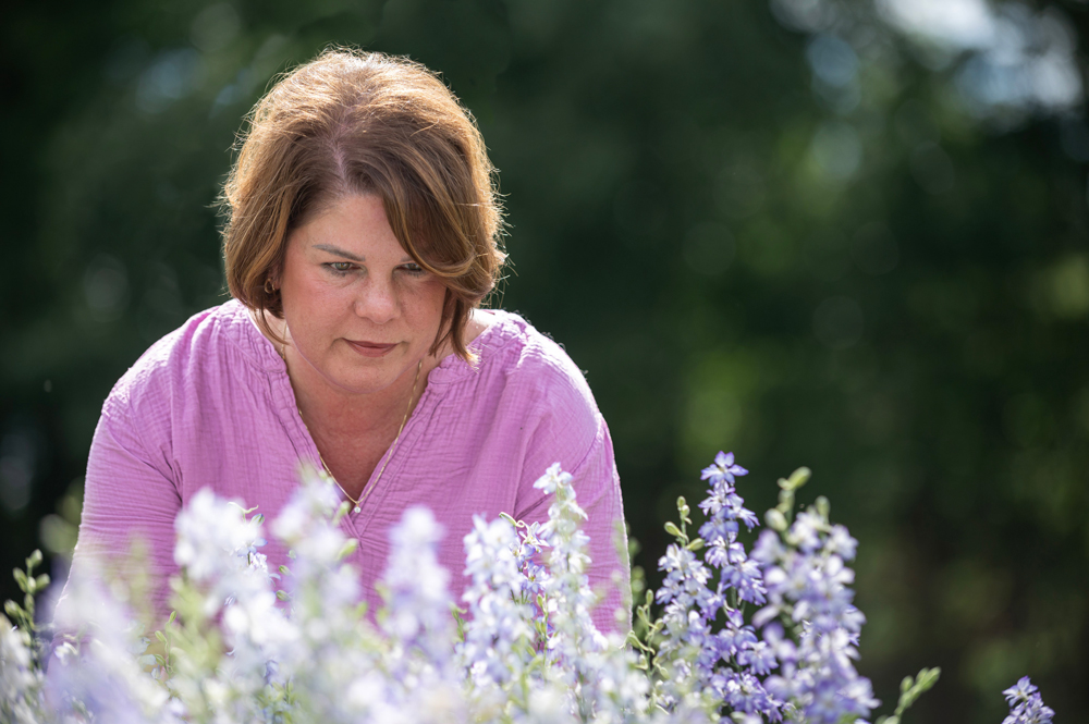 A person examining growing flowers.