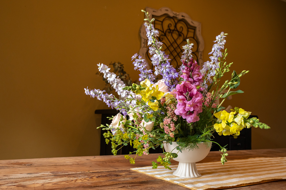 An arrangement of cut flowers in a vase on a table.