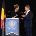  A person accepts a plaque from another person.