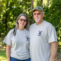 Two people wearing Newton County 4-H shirts standing outside and smiling.