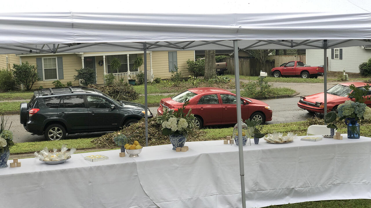 From inside a tent, cars can be seen lined up on the street.