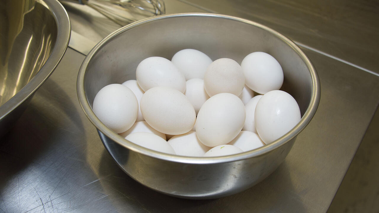 Several eggs sit in a bowl on a kitchen counter.