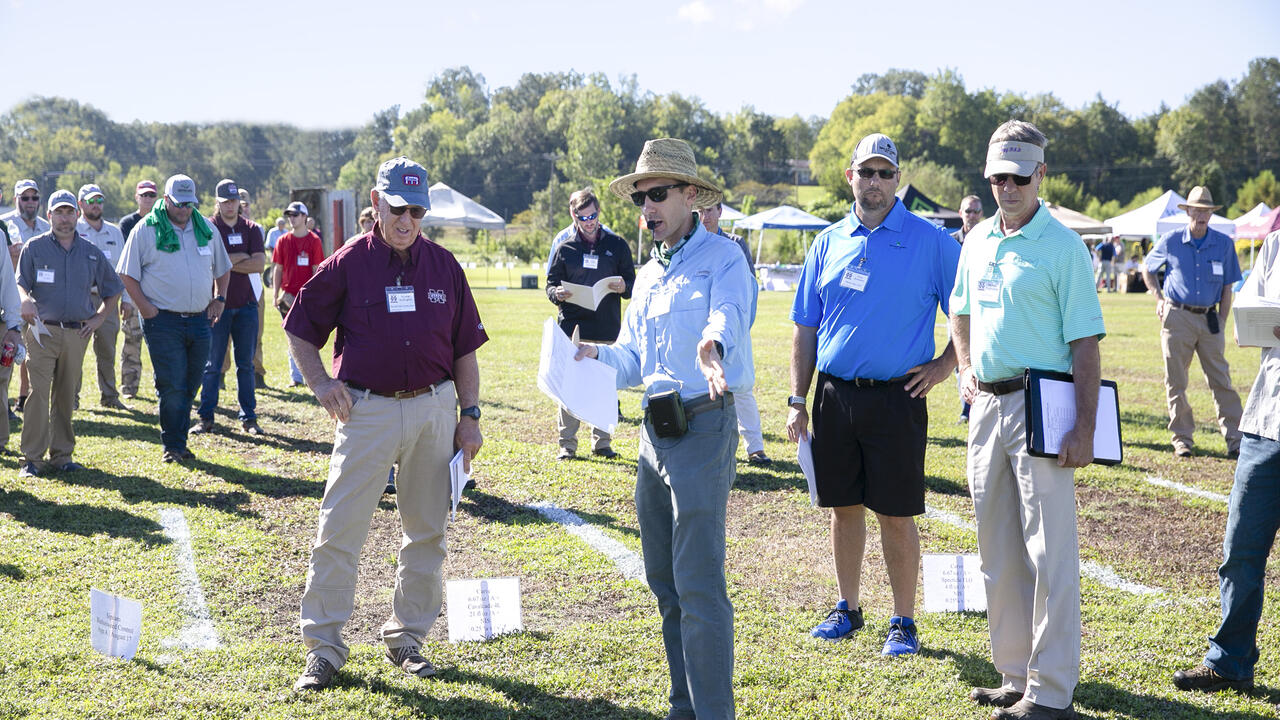 A group of people stand in a grassy field.