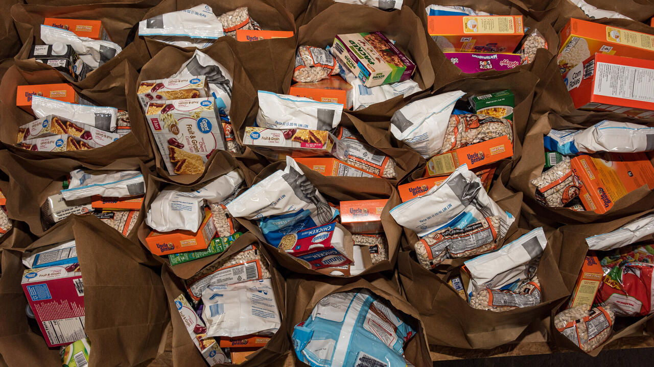 Paper bags are filled with grocery items.