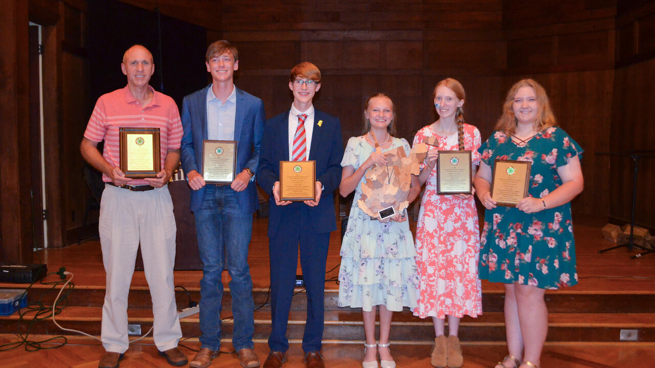 A group of people holding awards.