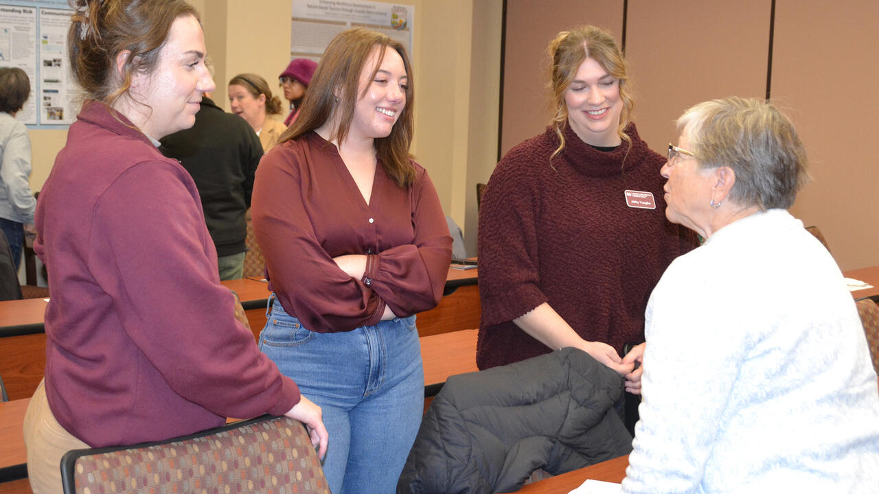 Four people in a small group talk.