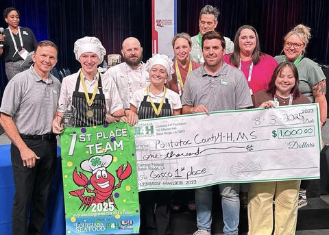 A group of people hold an oversized award check.