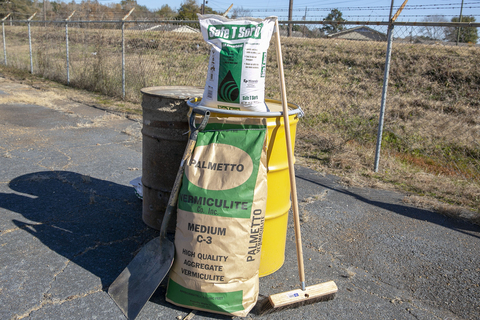One large bag and one small bag of absorbent material, a large shovel, and a large broom.