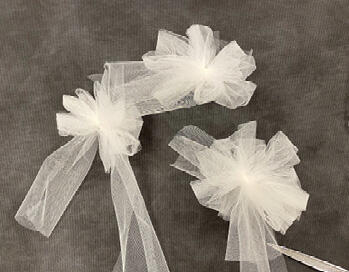 Corsage with white flowers and greenery.