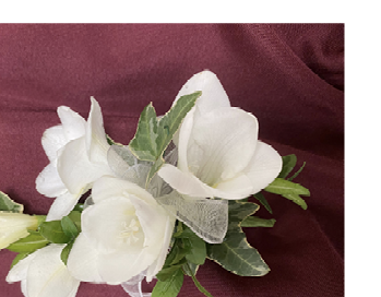 Corsage with white flowers and greenery.
