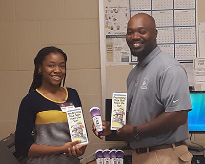 Presenting the Director of Public Works for the City of Clinton with sunscreen lotion and skin and sun safety brochures.