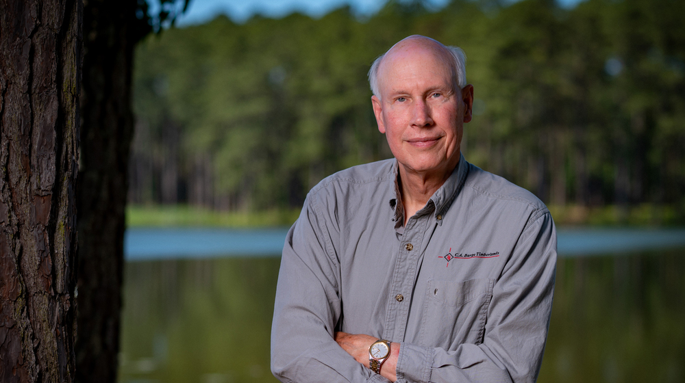 A man standing in front of a lake.